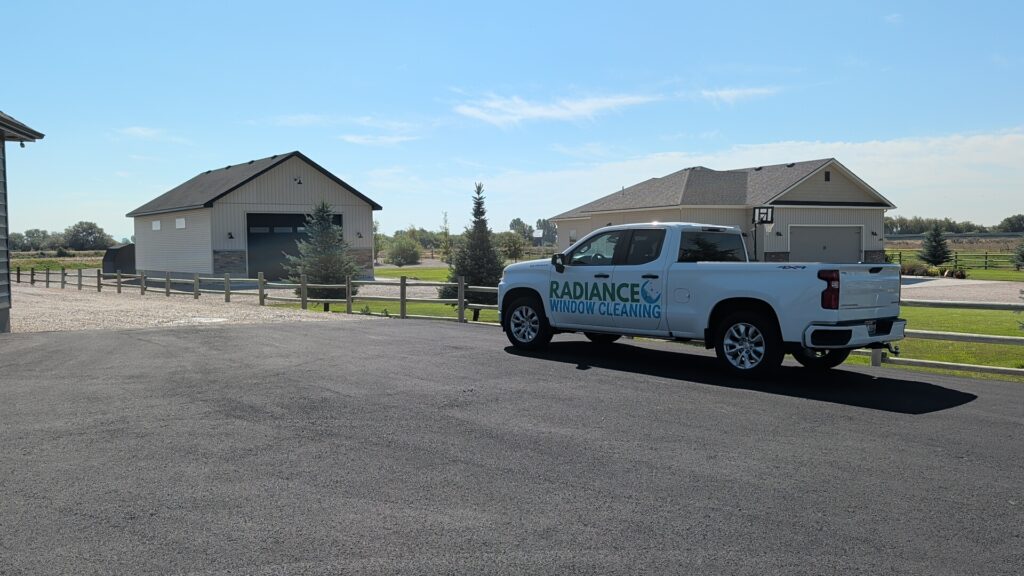 Radiance Window Cleaning white work truck parked on pavement by rural homes, window cleaning service in Shelley, Idaho